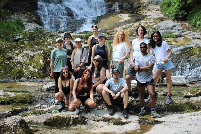 Gruppe von Schülerinne und Schülern mit Lehrerinnen vor einem Wasserfall